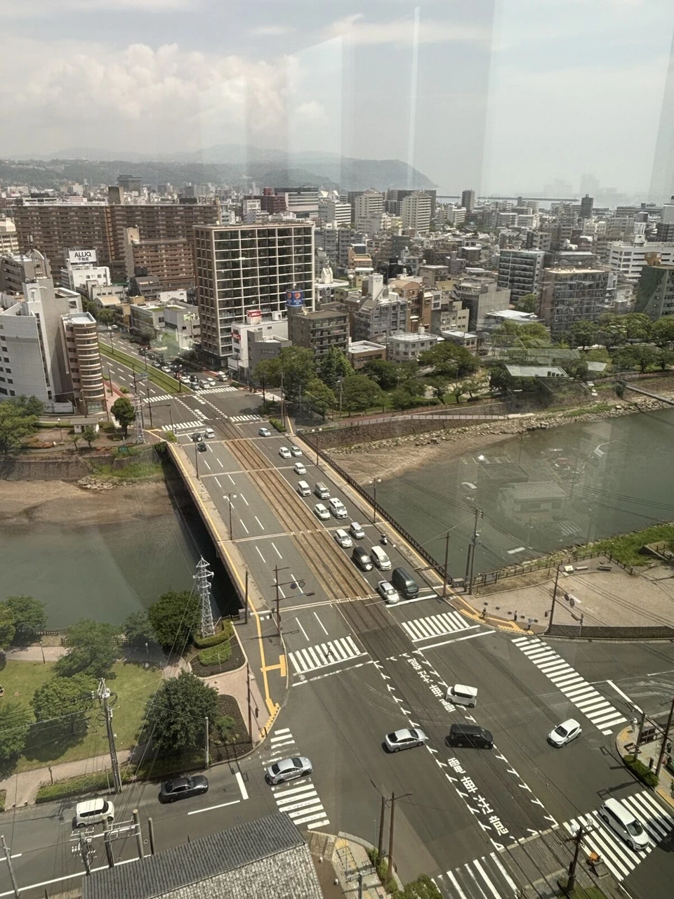窓から見た甲突川にかかる橋と街並み