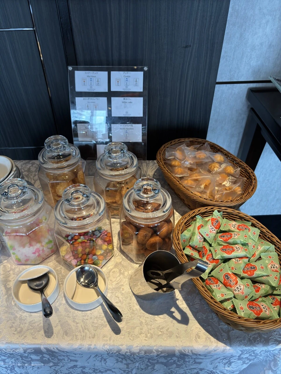 シェラトン都ホテル大阪のクラブラウンジに並ぶお菓子の瓶と個包装のおやつ