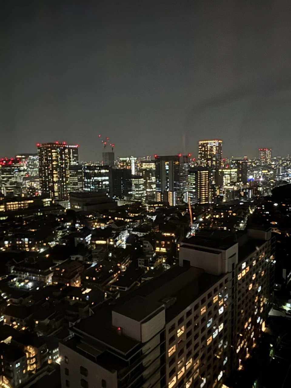 品川プリンスホテルの高層階の客室窓から見た夜景。手前に住宅やマンション、奥に高層ビルの明かり