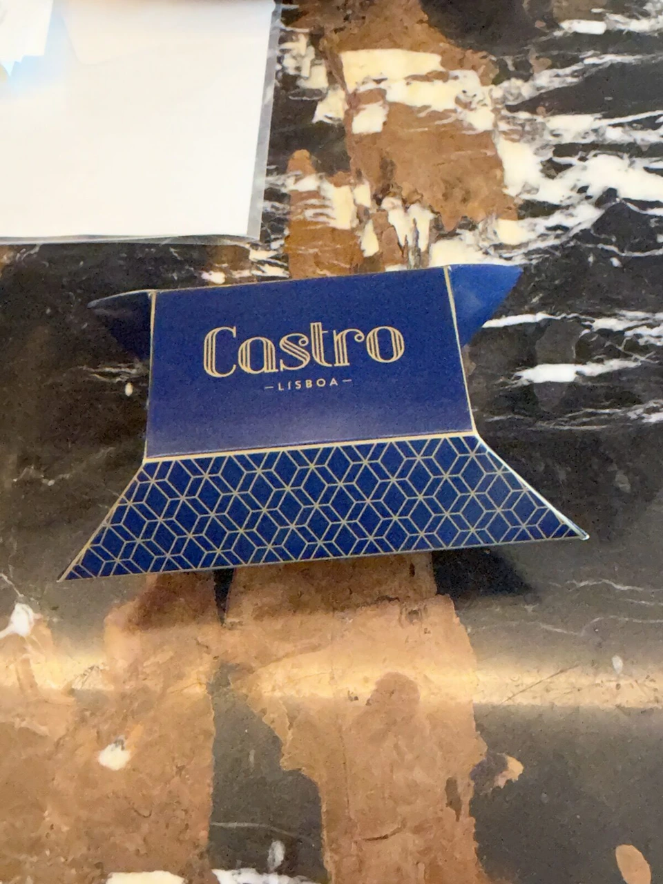 大理石の台に置かれた、Castro LISBOAと書かれた紺色の小箱のお菓子