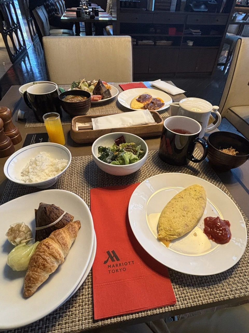 東京マリオットホテルの朝食のテーブル。オムレツ、クロワッサン、サラダ、ご飯、マリオットの赤いナプキン