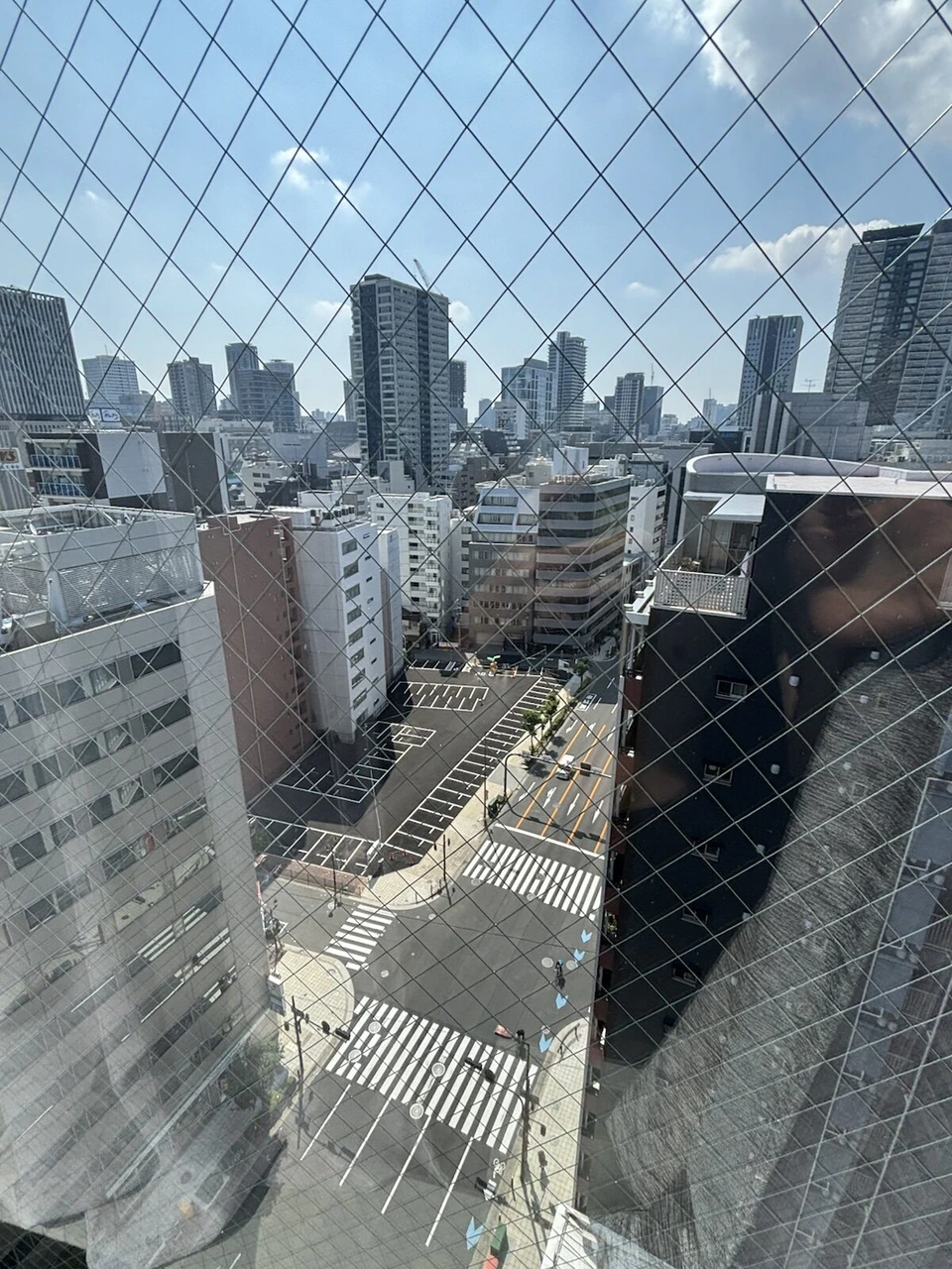 voco大阪セントラルの客室の網入りガラス越しに見下ろした交差点と周りのオフィスビル