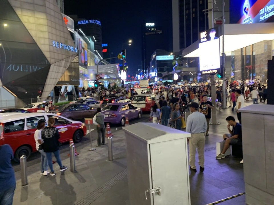 夜のブキッビンタン通りの交差点。人と車でいっぱい