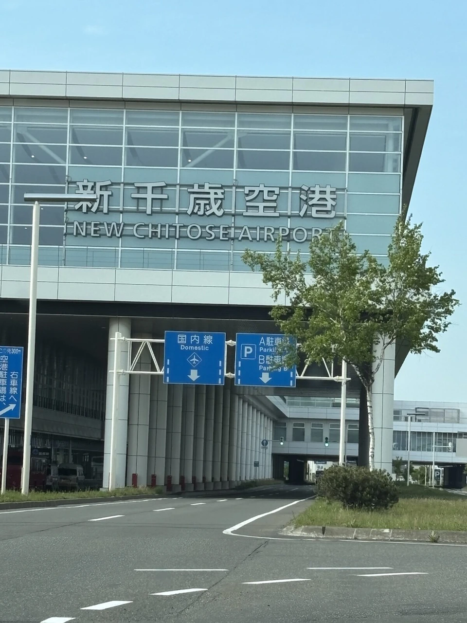 晴れた日の新千歳空港ターミナルの外観。NEW CHITOSE AIRPORTの文字