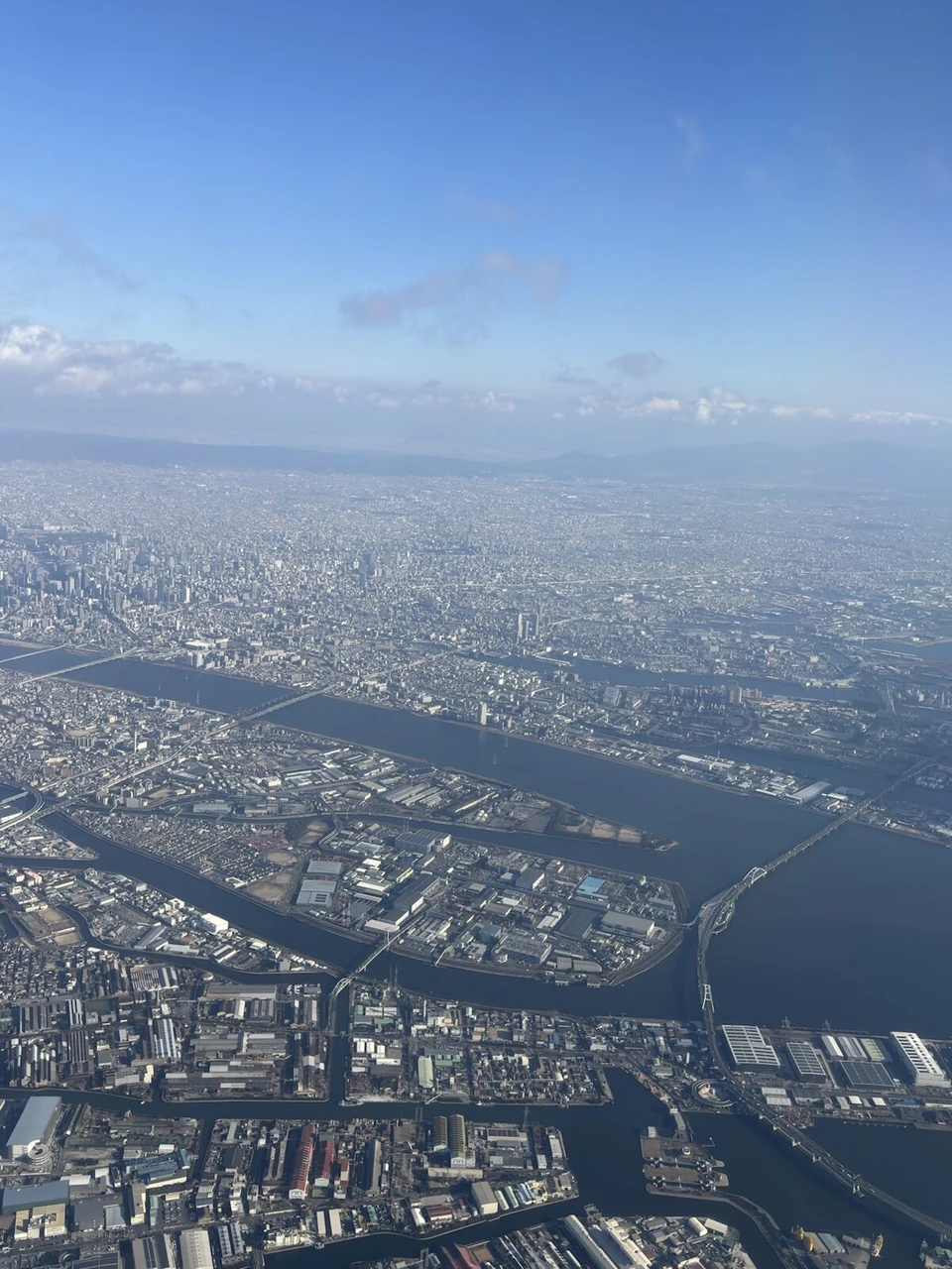 JL2087で伊丹から那覇へ向かう機内の窓から見た大阪湾岸の街と川