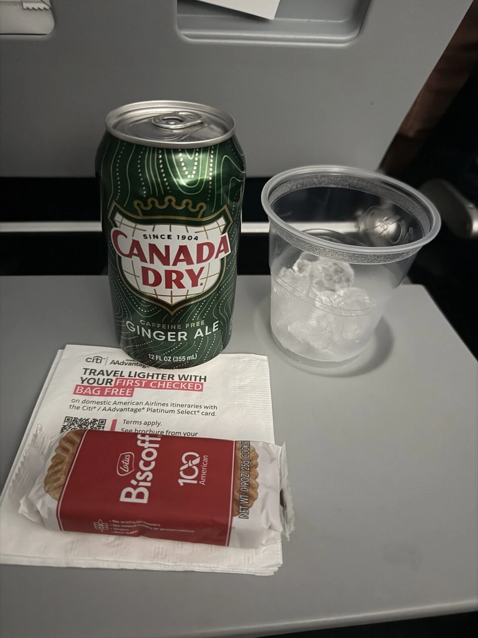 AA1557の機内で配られたカナダドライのジンジャーエールとBiscoffのクッキー