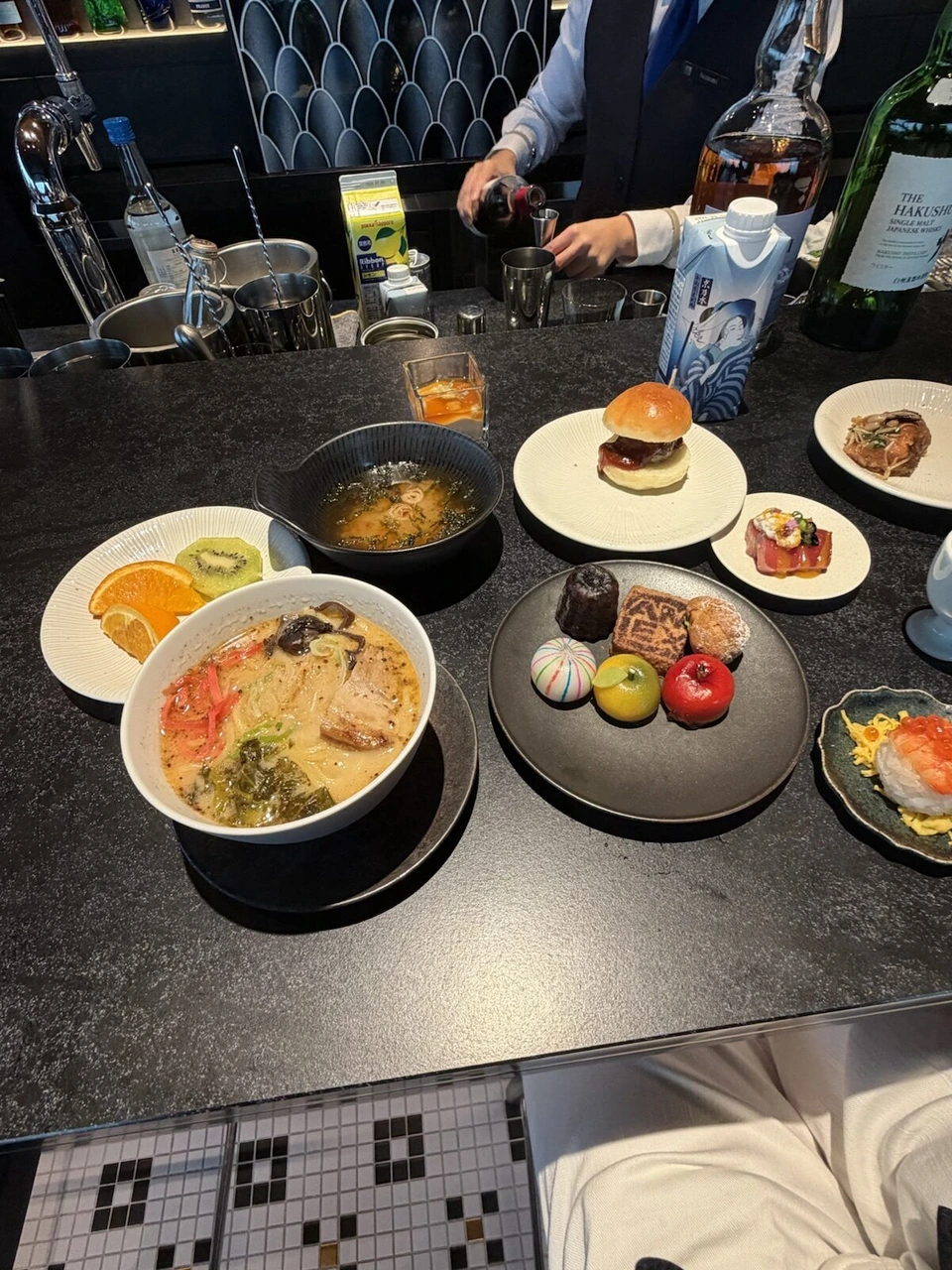 第3ターミナルのJALのラウンジのバーカウンター。豚骨ラーメン、スープ、ミニバーガー、手まり寿司