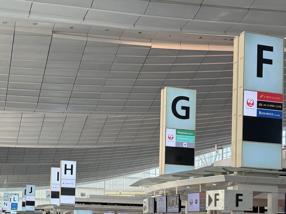 羽田空港第3ターミナルの出発ロビー。高い天井の下にF・G・Hのカウンターの案内が並ぶ