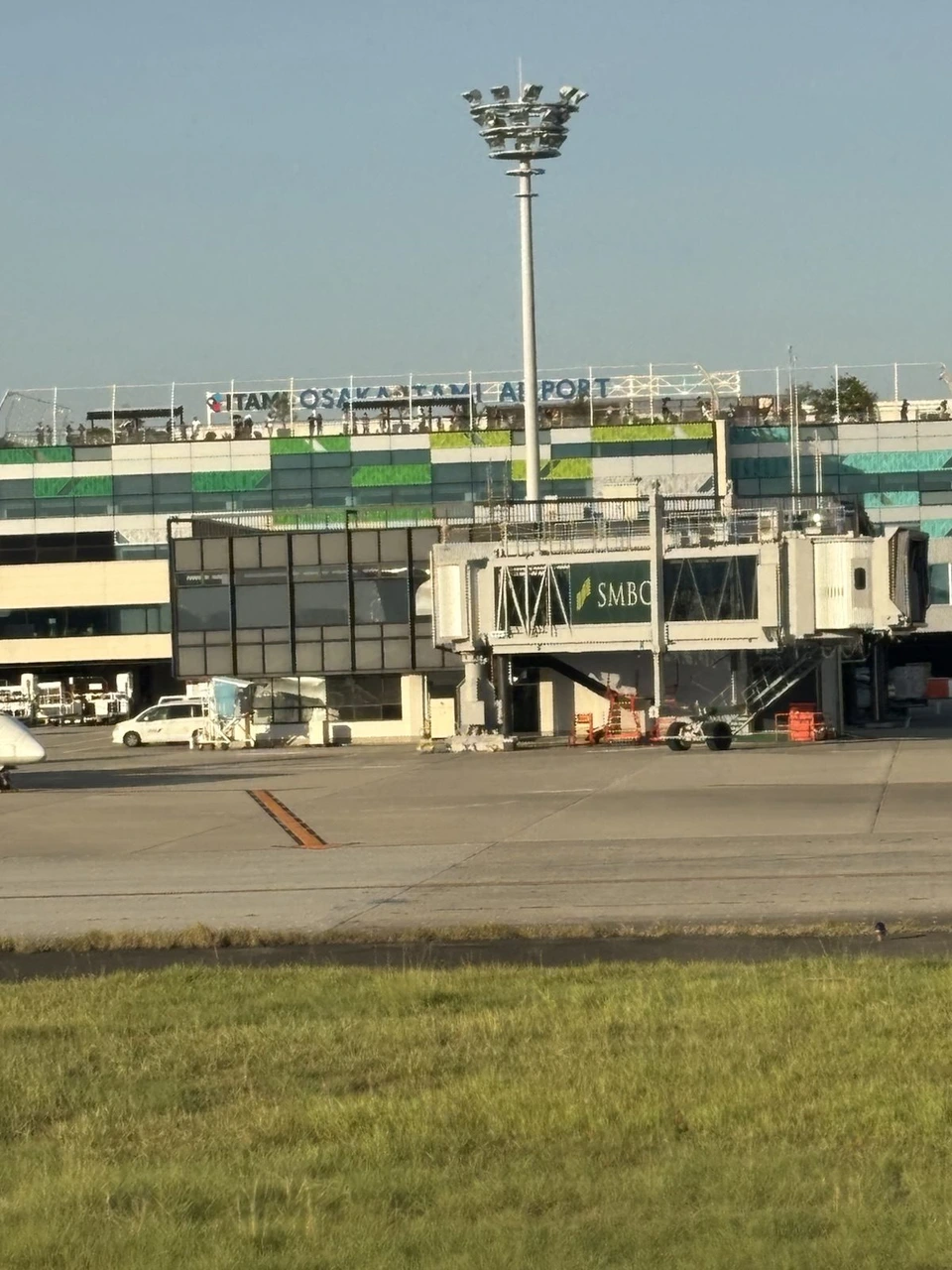 滑走路の向こうに見える伊丹空港のターミナル。屋上にOSAKA ITAMI AIRPORTの文字