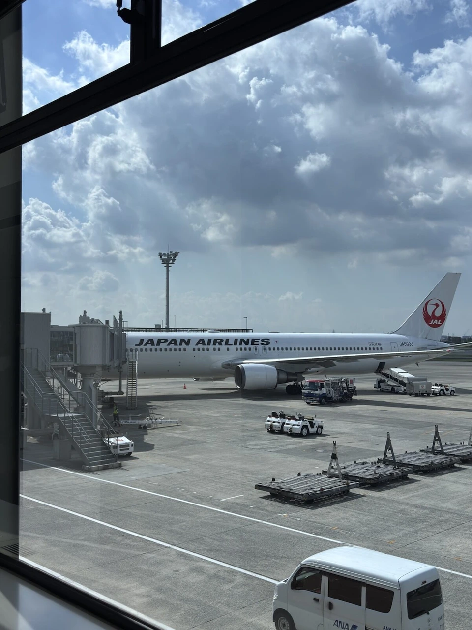 伊丹空港の窓から見た駐機中のJALの機体と、夏の雲