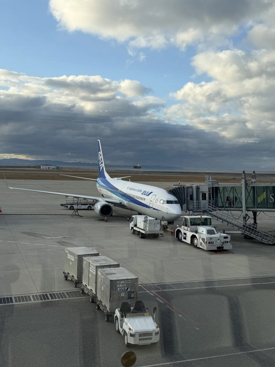 神戸空港5番搭乗口の窓から見た、ボーディングブリッジにつながるNH577のANAボーイング737