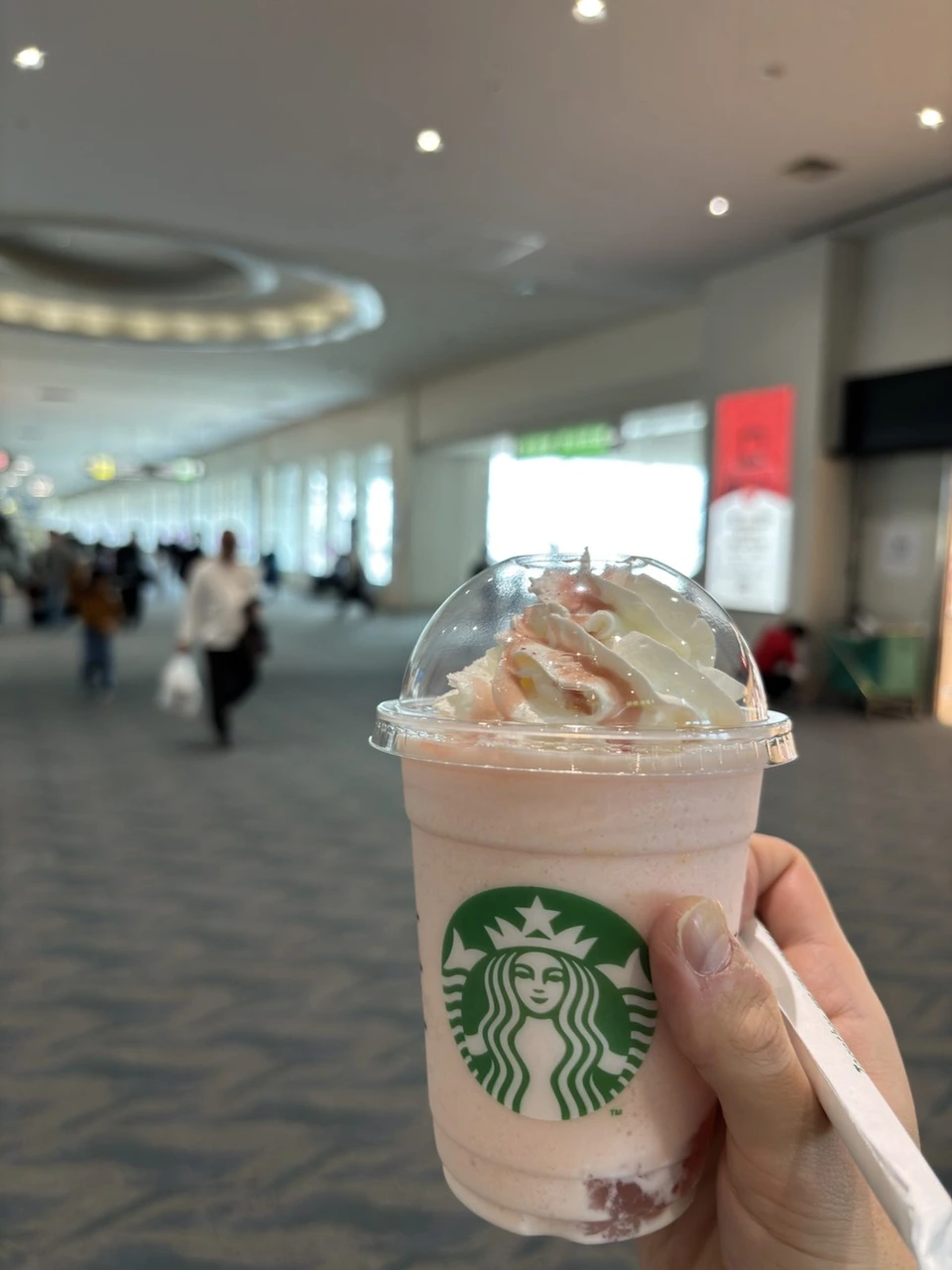 那覇空港国内線ターミナルの通路と、手に持ったスターバックスのピンクのフラペチーノ