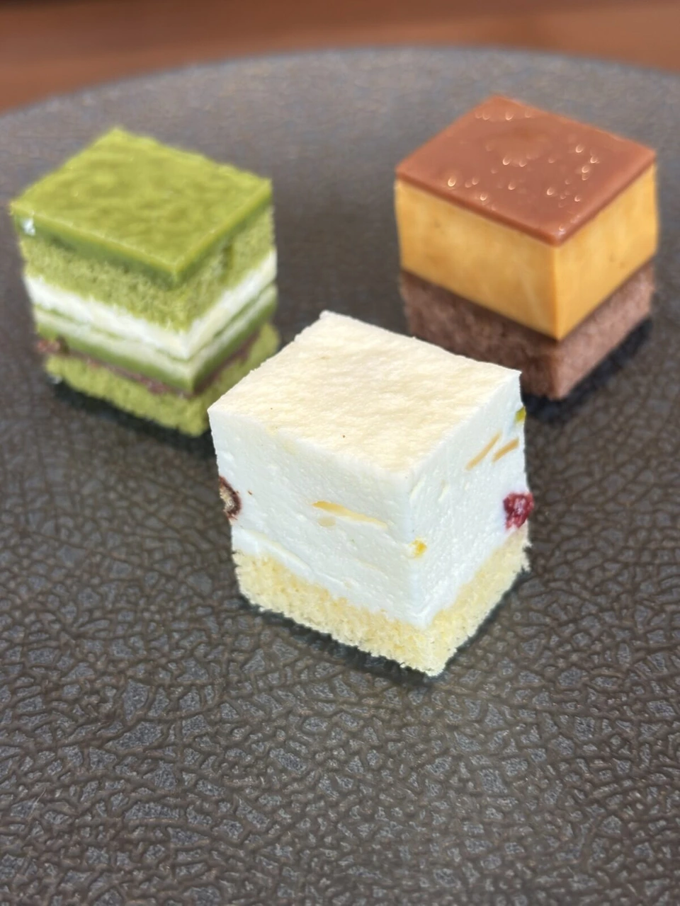 抹茶、チーズ、キャラメルの四角い小さなケーキ3つ