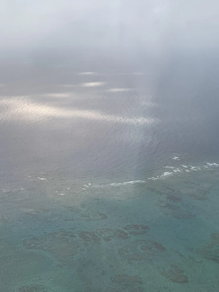 JL914の離陸後の機窓から見下ろした沖縄のサンゴ礁の海