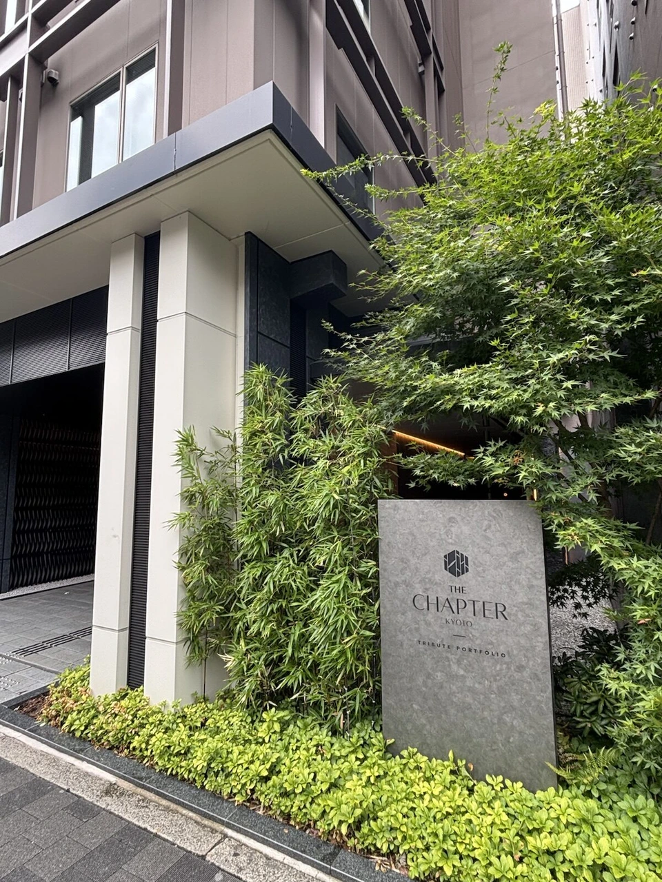 ザ・チャプター京都の入口。植え込みの中に建つ石の看板と建物