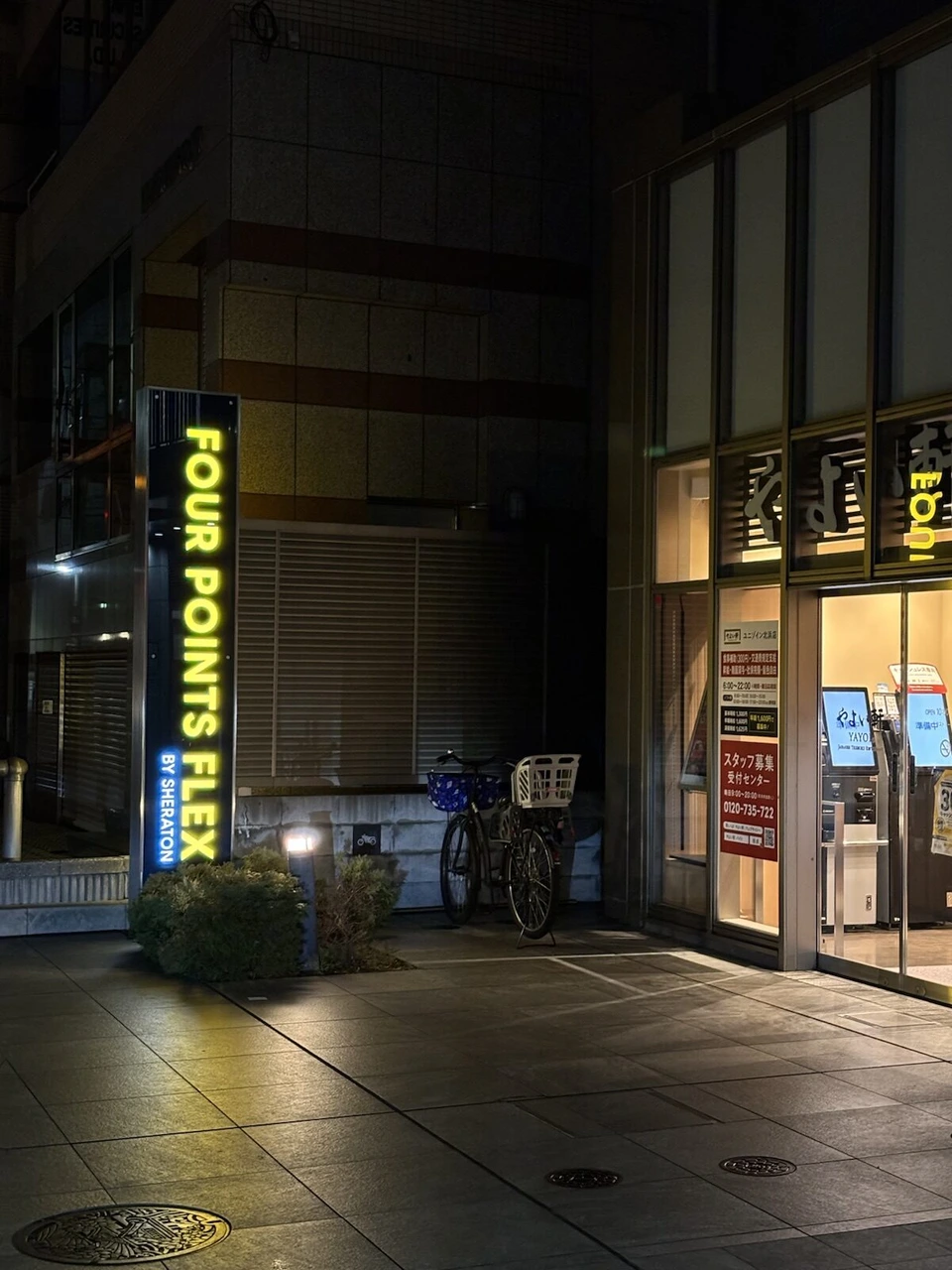 夜のフォーポイント フレックス大阪北浜の入口。黄色く光る縦長の看板