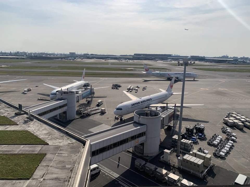 羽田空港の展望デッキから見た、搭乗橋につながるJALの機体