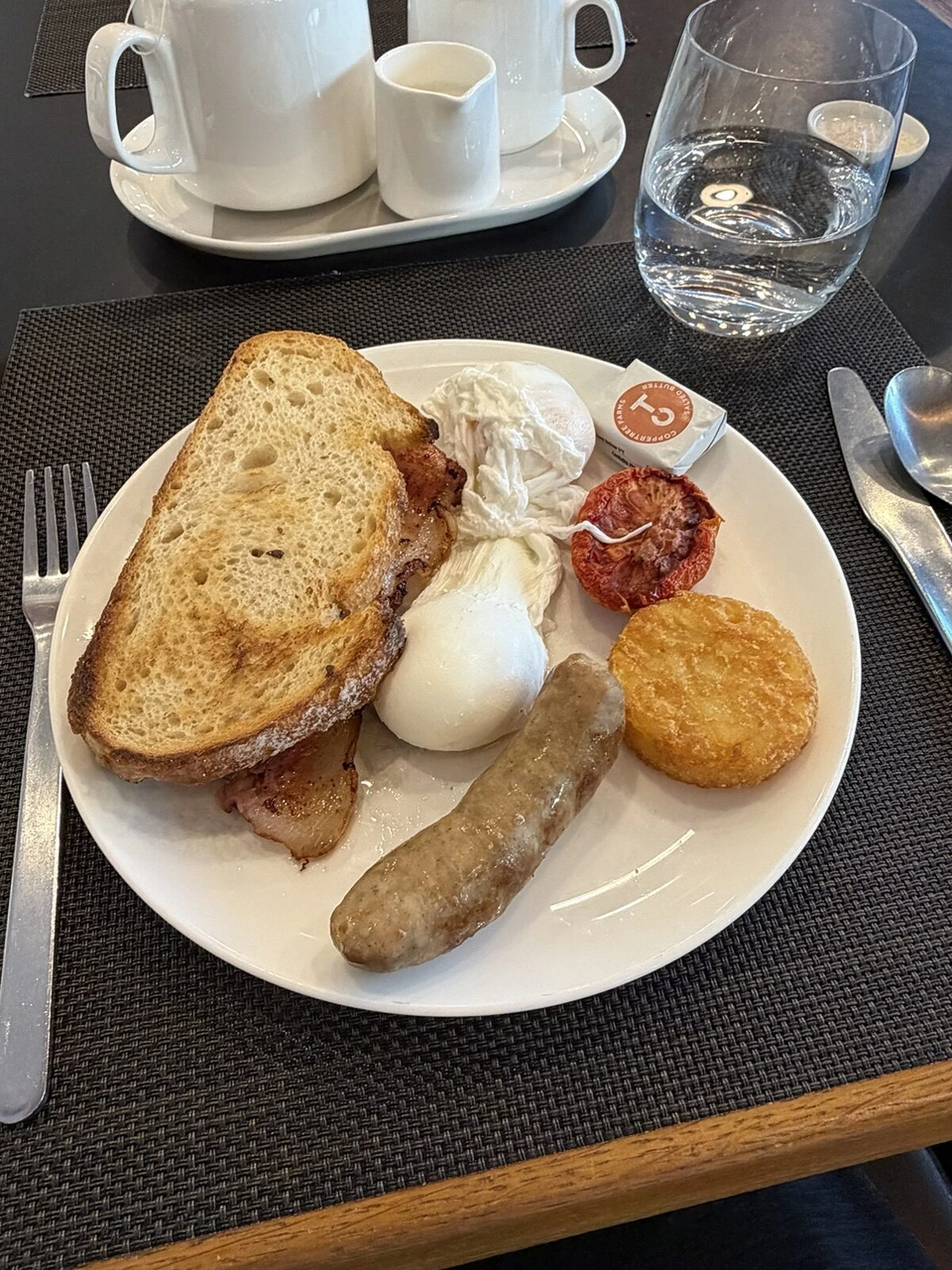 シドニー空港のカンタス・ファーストラウンジの朝食。トーストとベーコン、ポーチドエッグ、ソーセージ