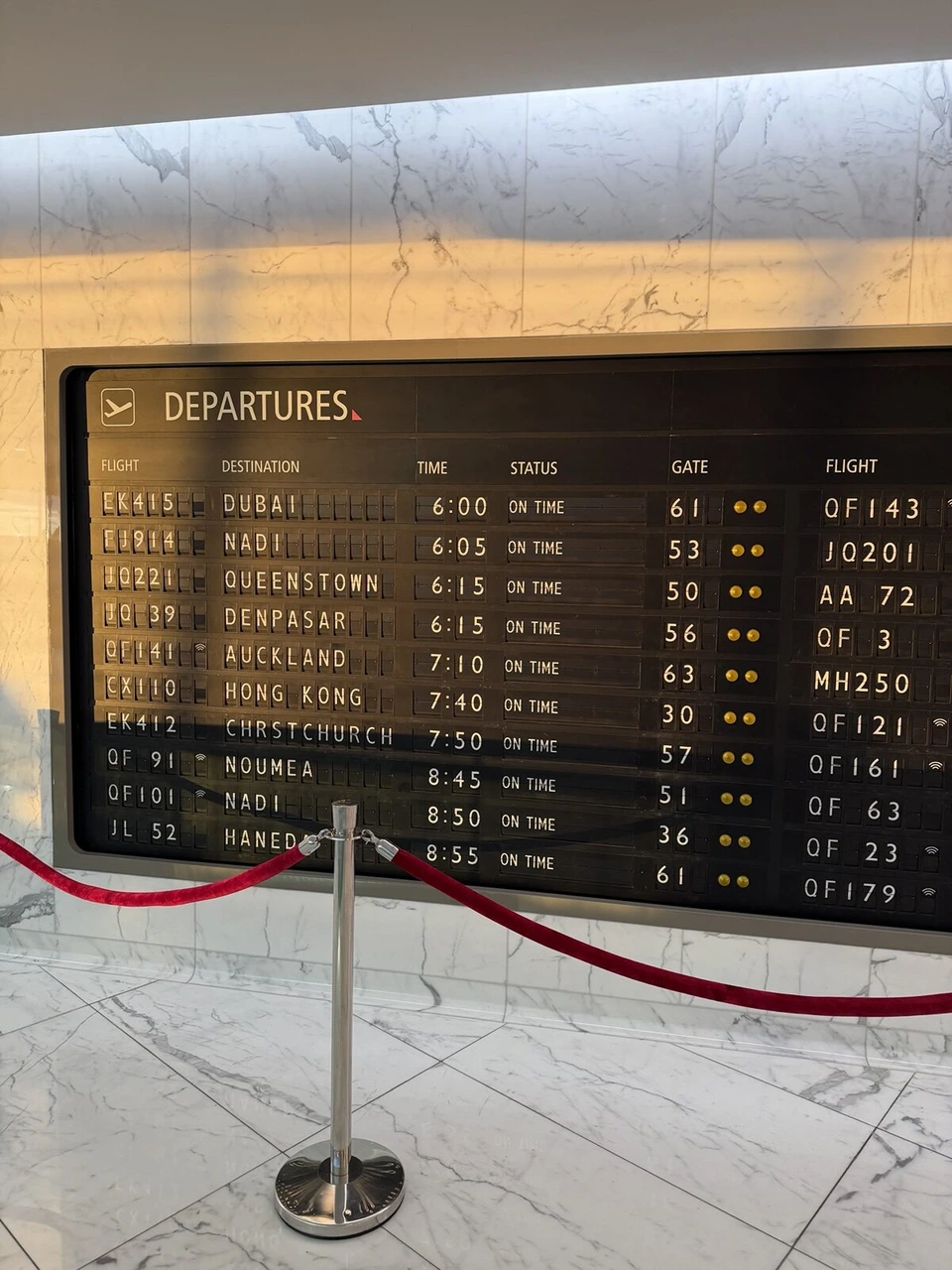 シドニー空港のカンタス・ファーストラウンジのパタパタ式の出発案内板。CX110 HONG KONG ON TIME
