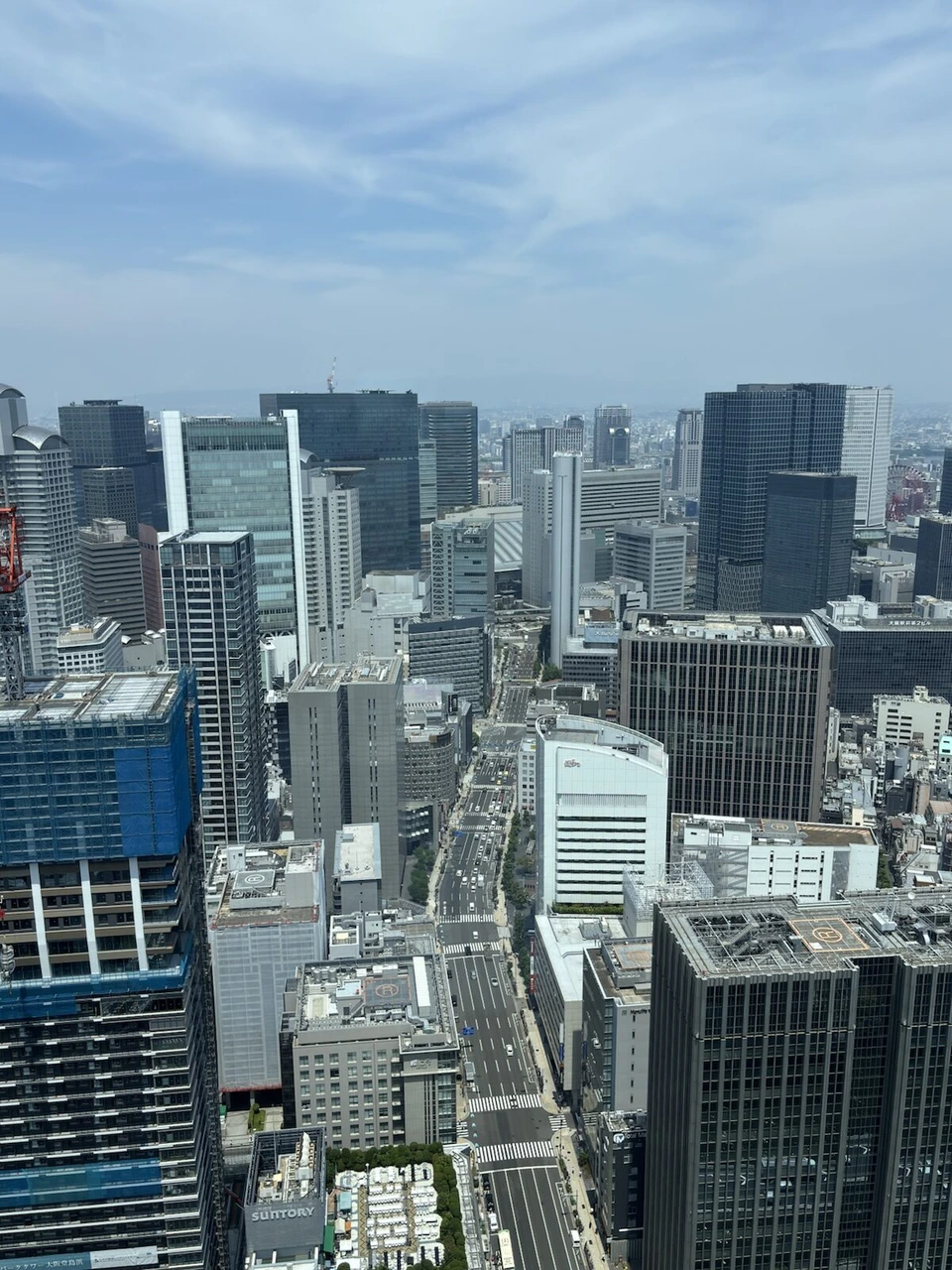 コンラッド大阪の高層階から見下ろした大阪のオフィス街と広い道路、遠くの山