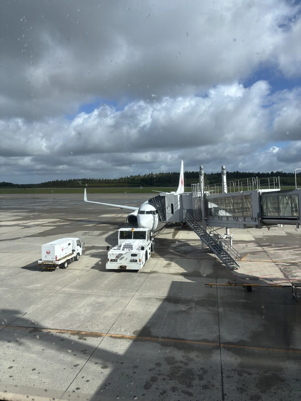 秋田空港の駐機場に止まるJALのボーイング737とボーディングブリッジ