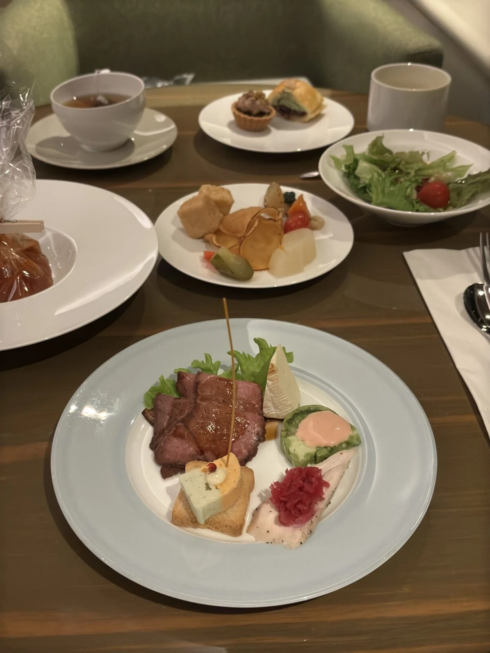 クラブラウンジのバータイムの料理。ローストビーフ、サーモン、サラダ、揚げ物、スイーツ