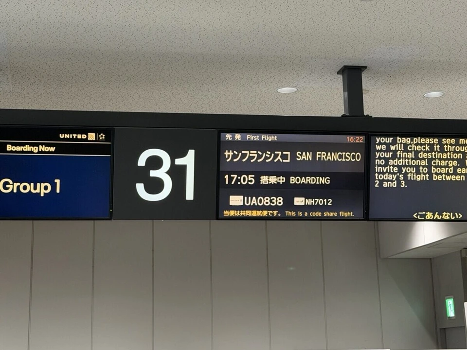 成田空港31番ゲートの案内表示。UA0838 サンフランシスコ 搭乗中、Group 1、NH7012との共同運航の表示