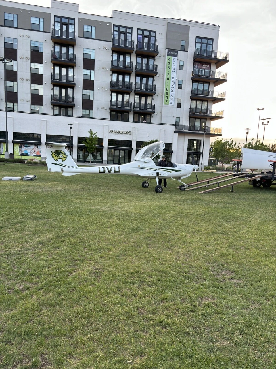 芝生に展示されたUVUの小型飛行機と、新しい集合住宅