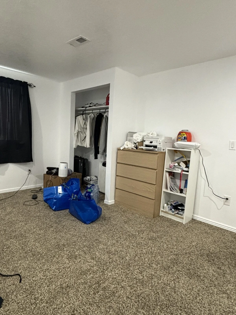 IKEAの家具をそろえた部屋。チェストと白い棚、黒いカーテン