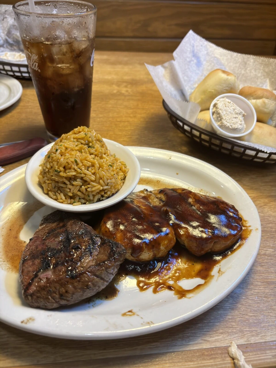 ステーキと照り焼き風チキン、味付けご飯、ロールパンとバター