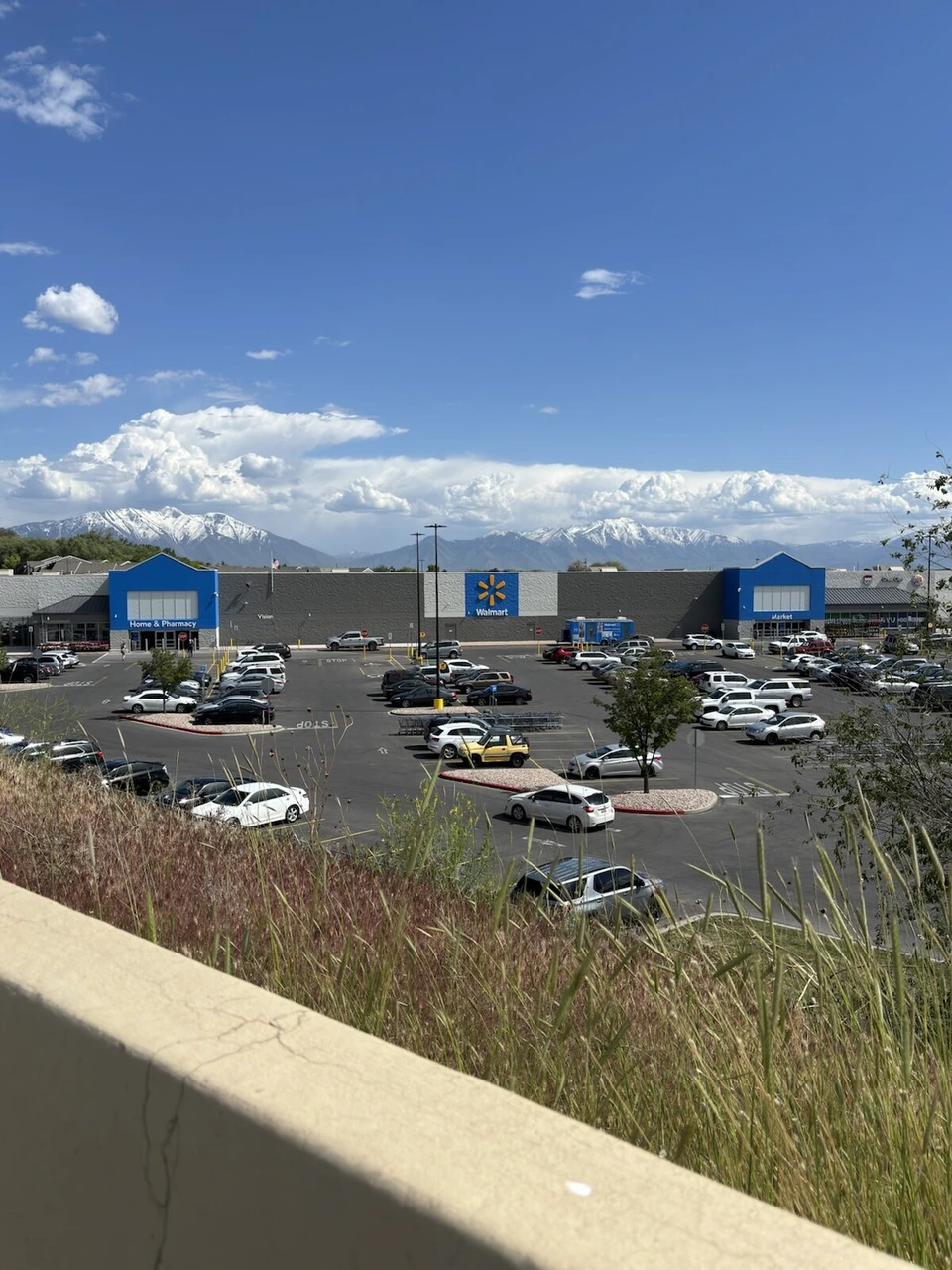 雪の残る山を背にしたウォルマートの店舗と、広い駐車場