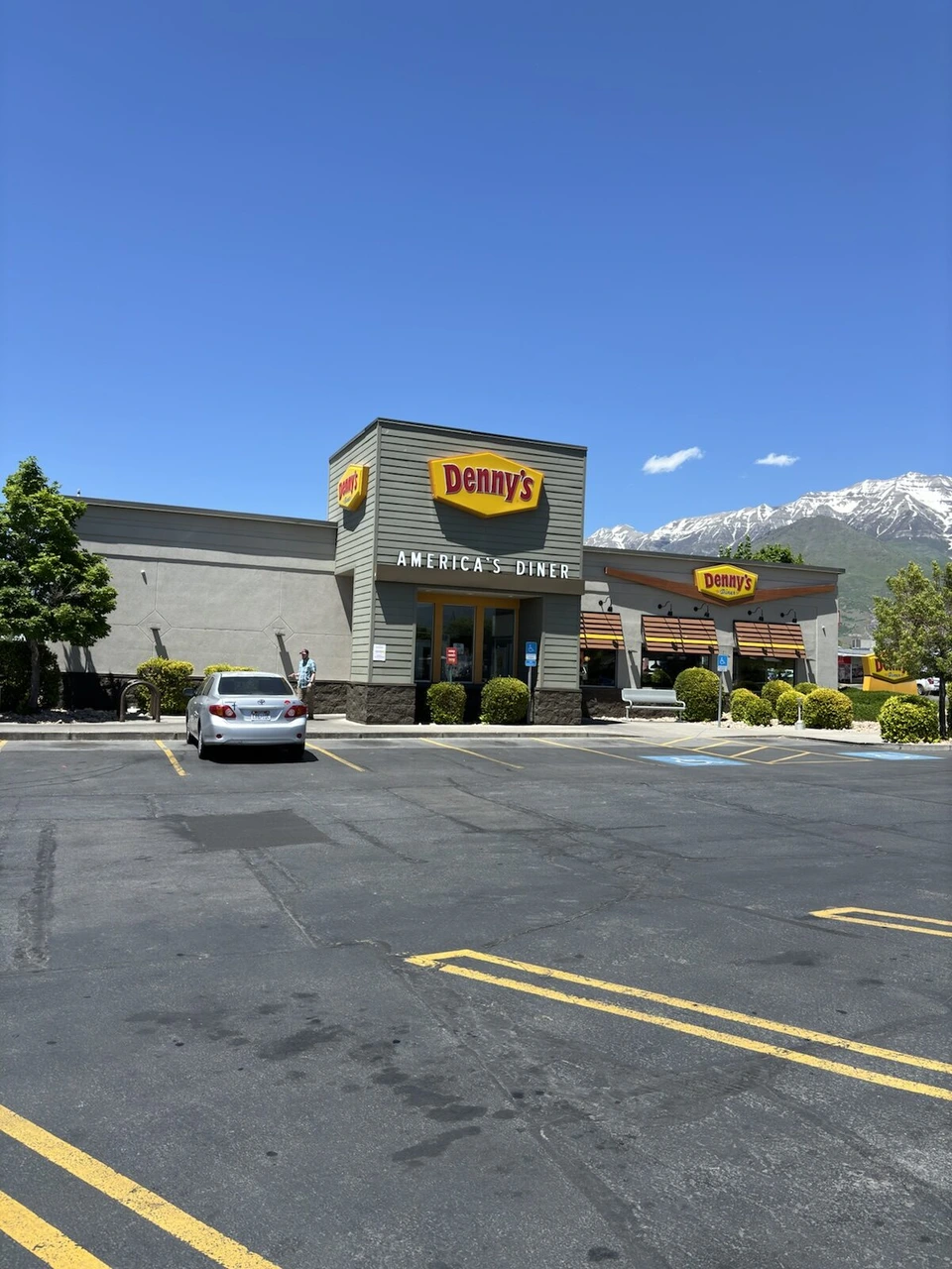 雪の残る山を背にしたデニーズの店舗