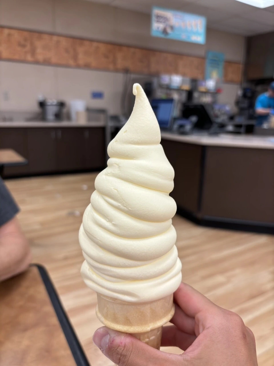 手に持った高く巻かれたソフトクリームのコーン