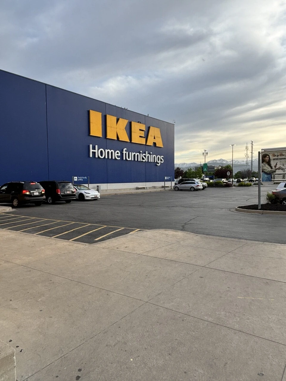 夕方のIKEAの青い建物と黄色いロゴ、駐車場