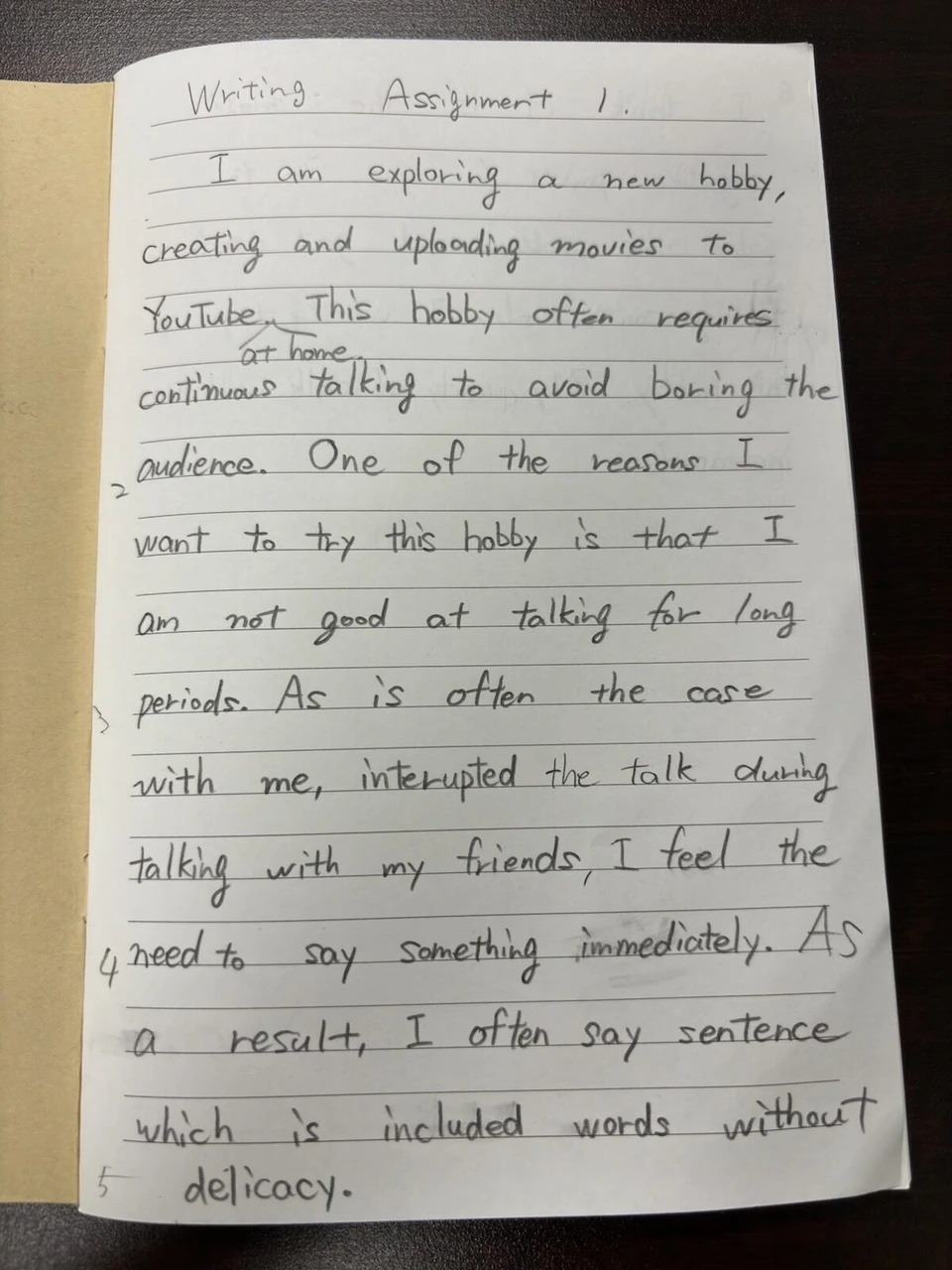 ノートに手書きした「Writing Assignment 1」の英文。新しい趣味としてYouTubeの動画づくりについて