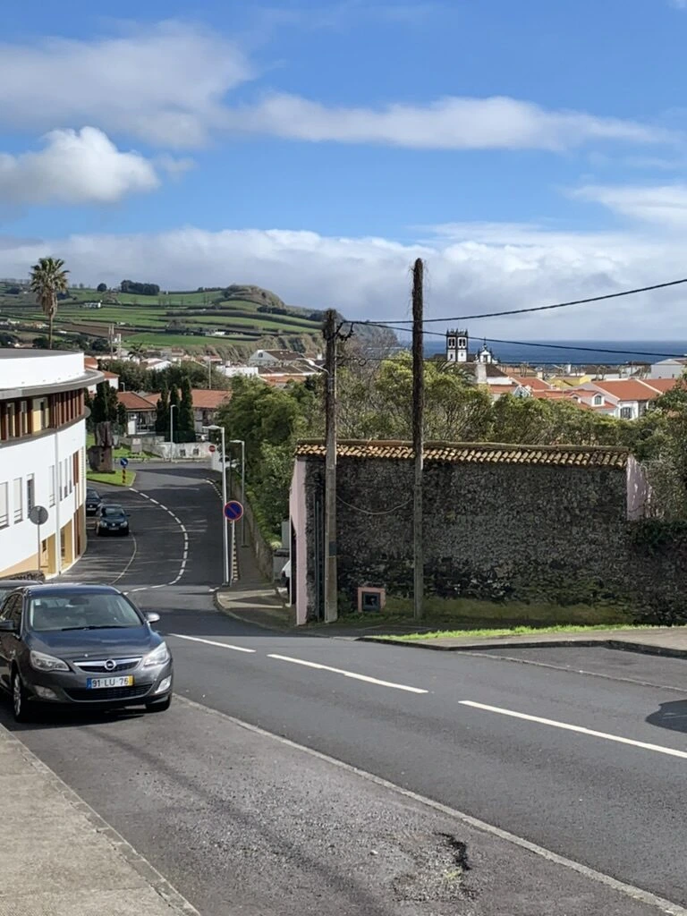 ポンタデルガダの坂道。奥に赤い屋根の町と海