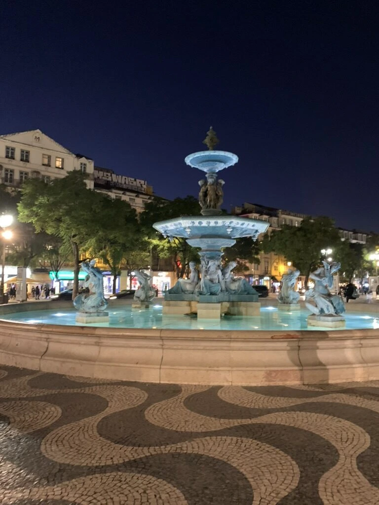 夜のロシオ広場。ライトアップされた噴水と記念柱