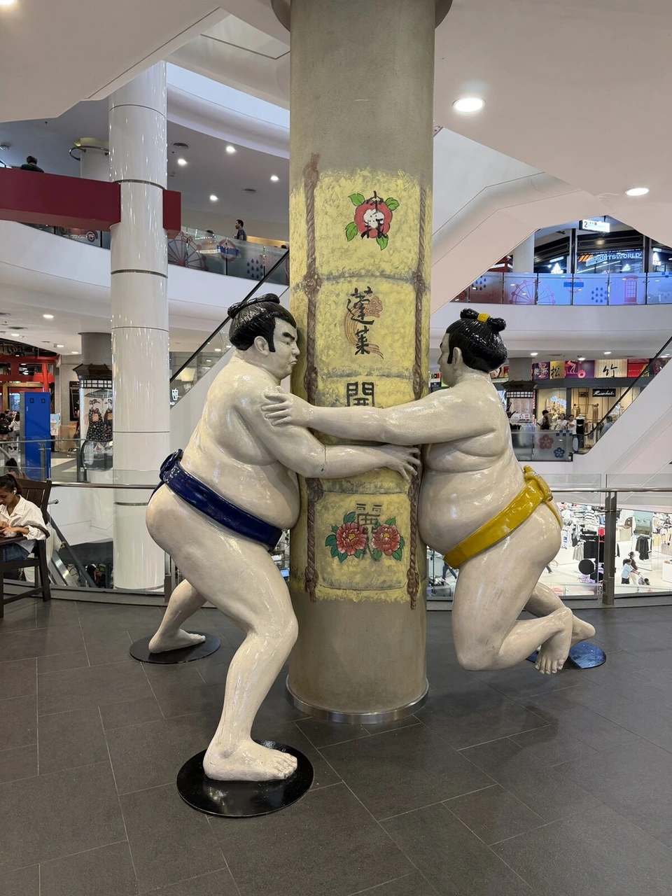 ターミナル21の館内にある、柱を押す2体の力士の像