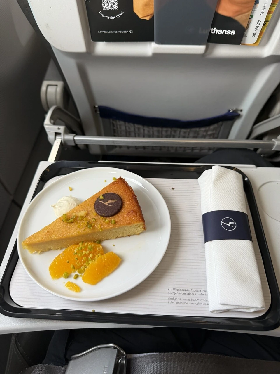 LH1196ビジネスクラスの軽食。オレンジを添えたケーキとナプキン