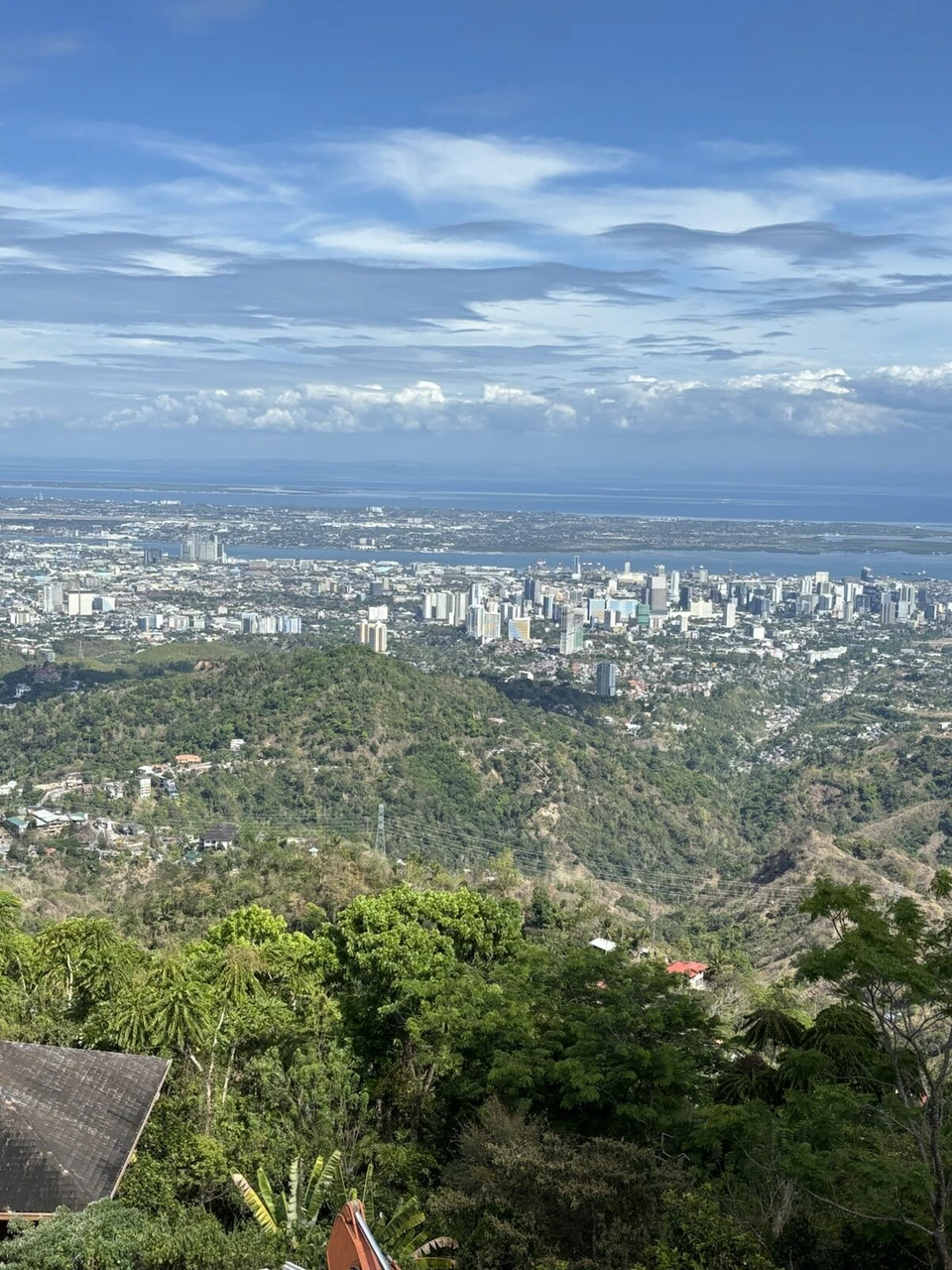 トップス展望台から見下ろしたセブ市街と海、青空に浮かぶ雲