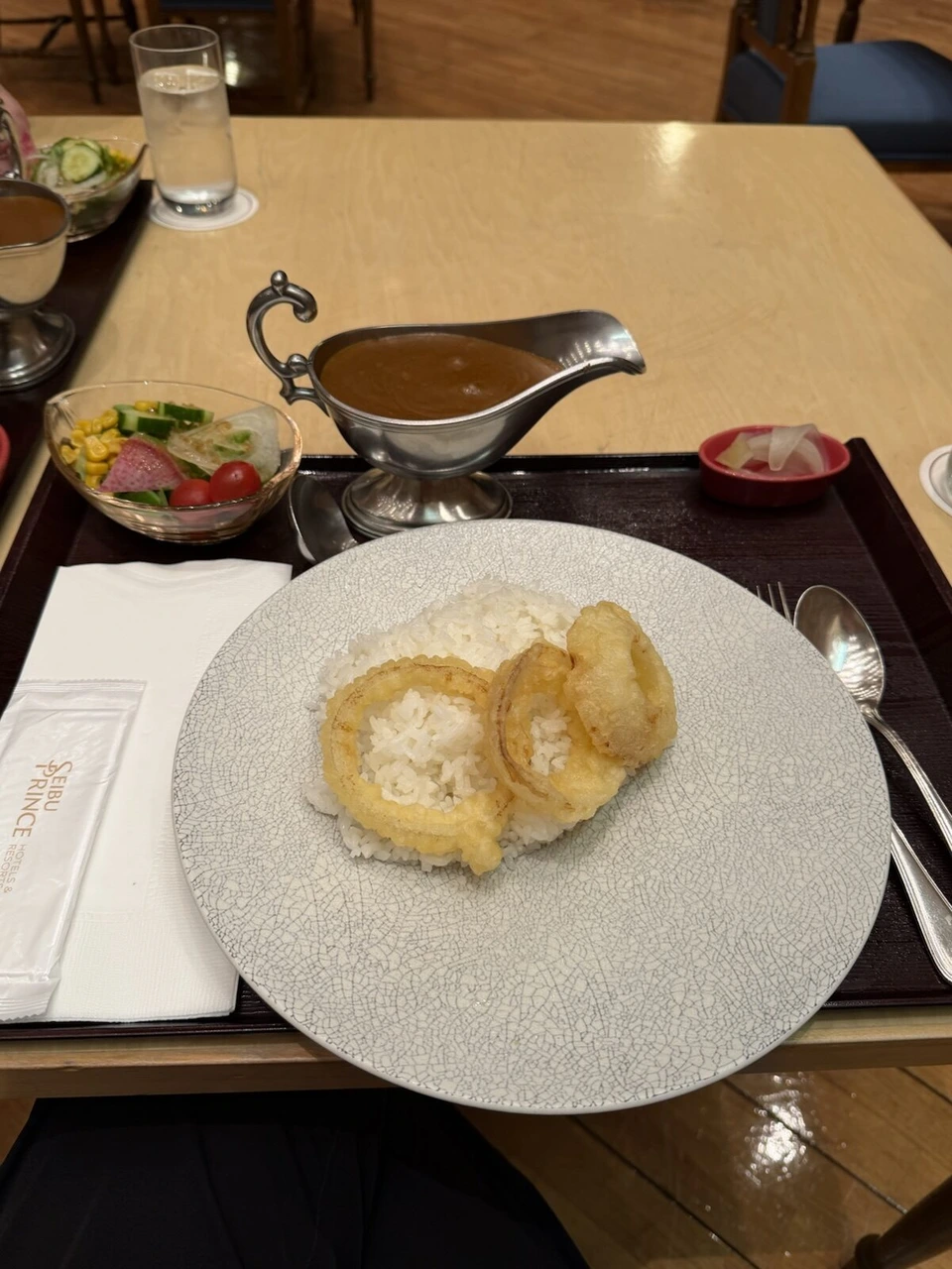 屈斜路プリンスホテルのレストランの夕食。リング状のフライがのったライスと銀のソースポットのカレー