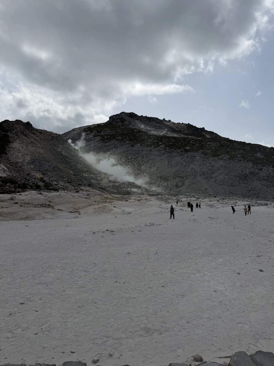 弟子屈の硫黄山（アトサヌプリ）。白い砂地の先の山肌から上がる噴気