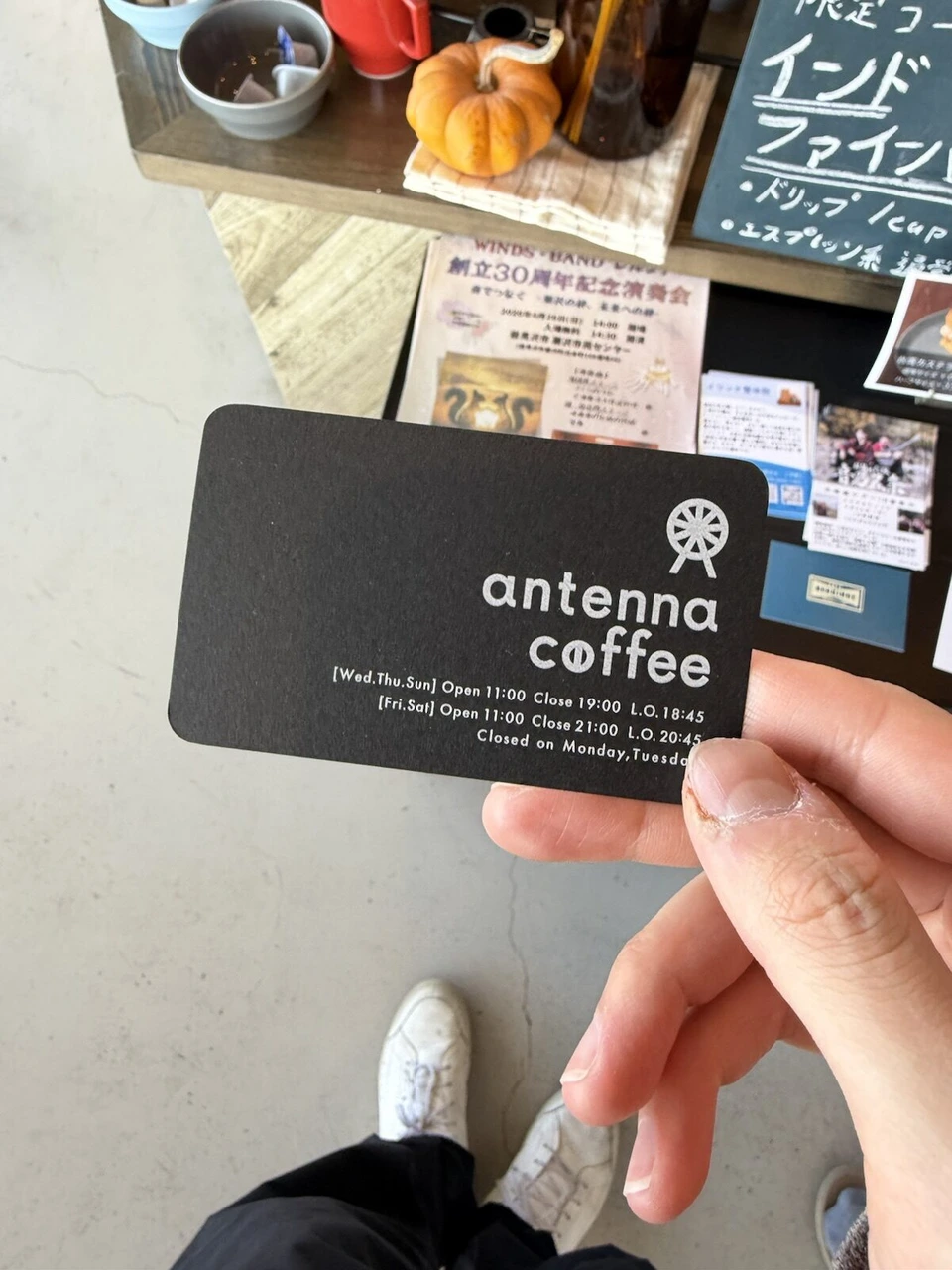 antenna coffeeのショップカード。黒地に観覧車のマークと営業時間
