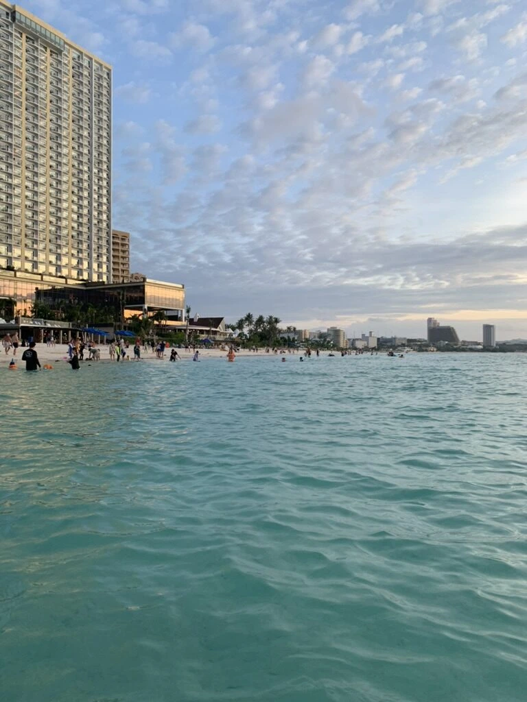 夕方のタモン湾。遠浅のエメラルド色の海と、ビーチ沿いの高層ホテル