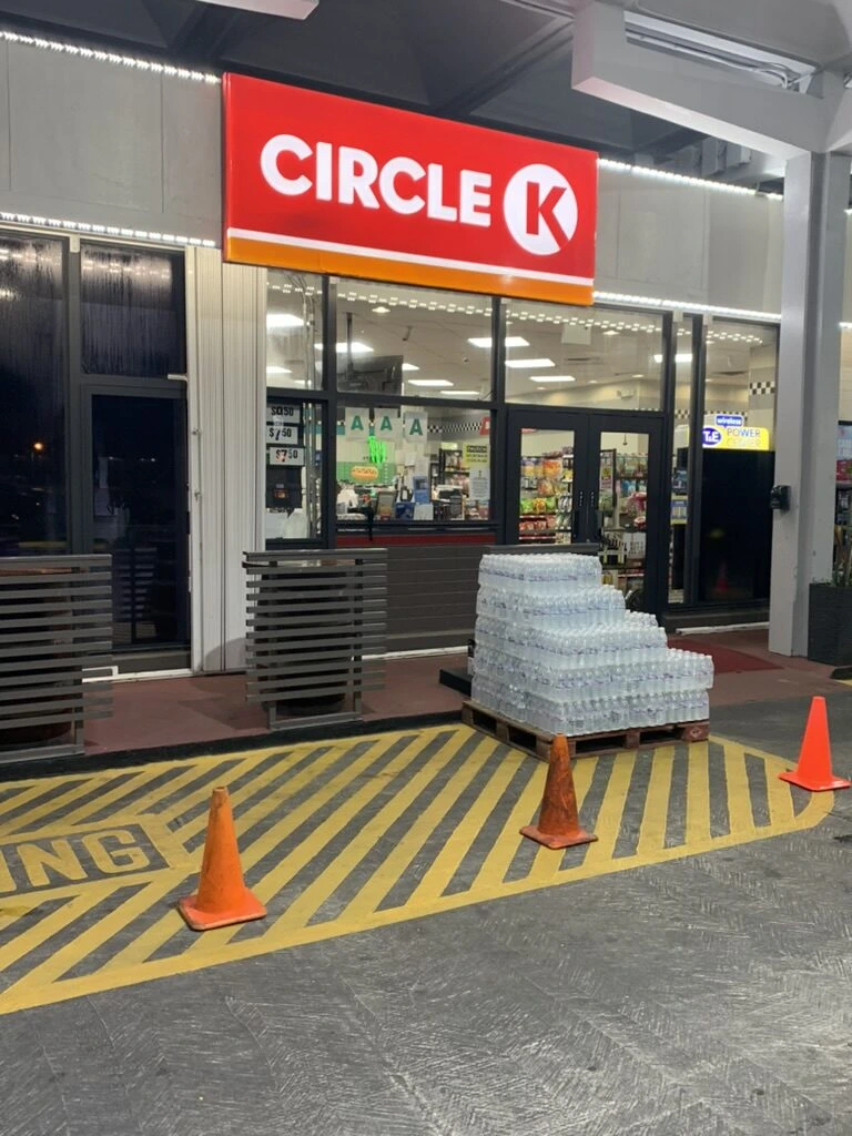 夜のグアムのサークルKの店舗。入口に水のケースが積まれている