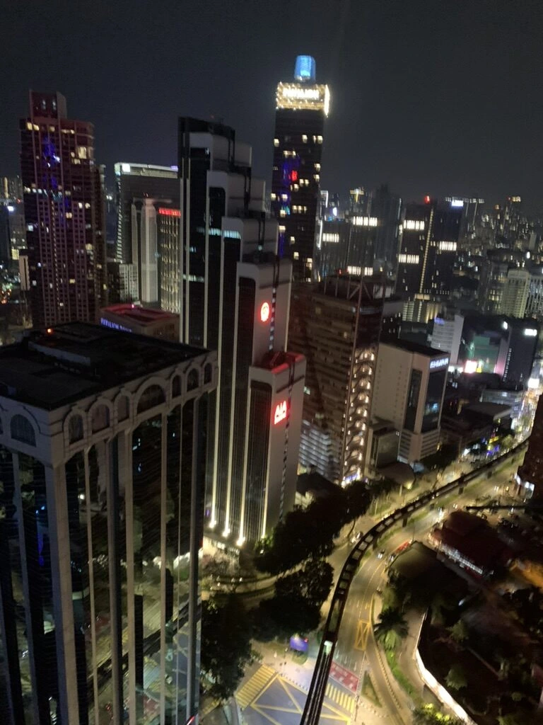 ヘリラウンジバーから見下ろしたクアラルンプールの夜景とカーブするモノレールの線路