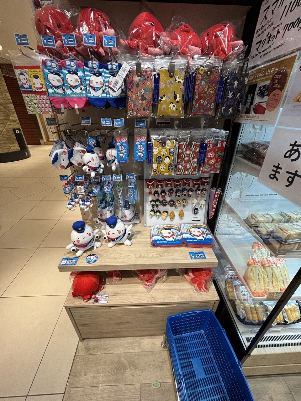 伊丹空港の売店。パイロット帽のキャラクターのぬいぐるみやキーホルダー、靴下が並ぶ棚