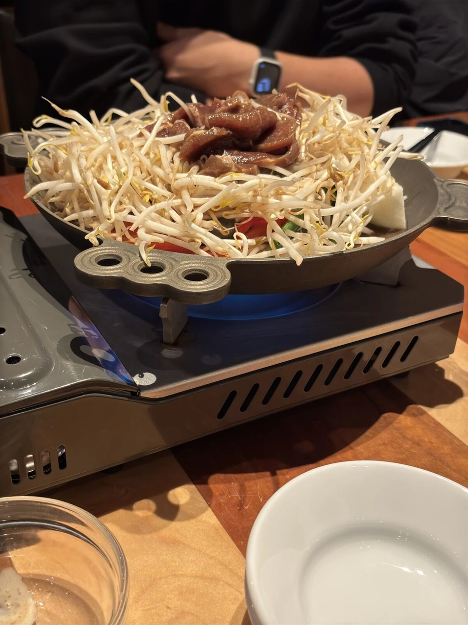 新千歳空港のお店のジンギスカン。鉄鍋に山盛りのもやしと羊肉、カセットコンロ