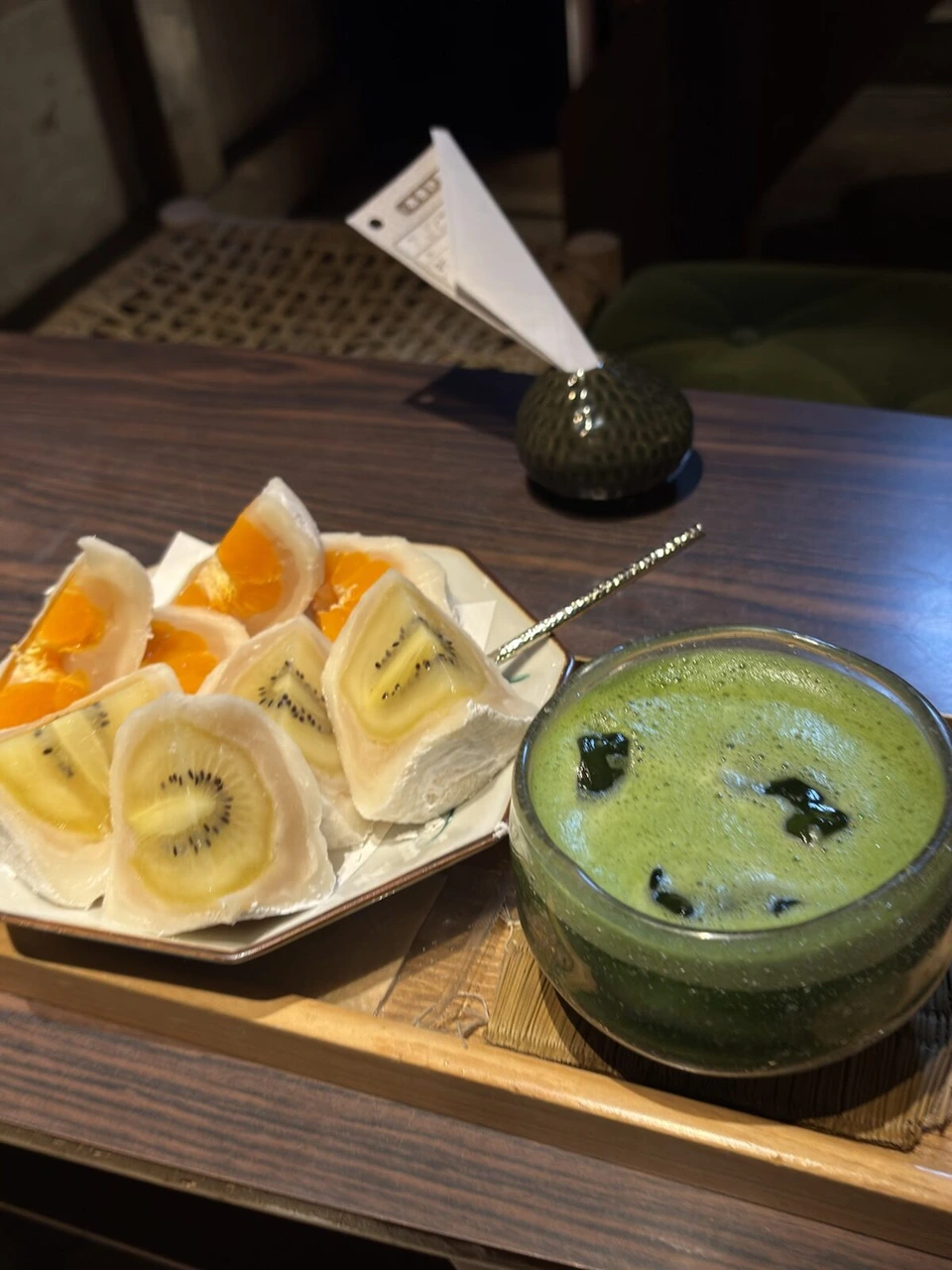 半分に切ったみかんとキウイのフルーツ大福と、抹茶のドリンクのグラス