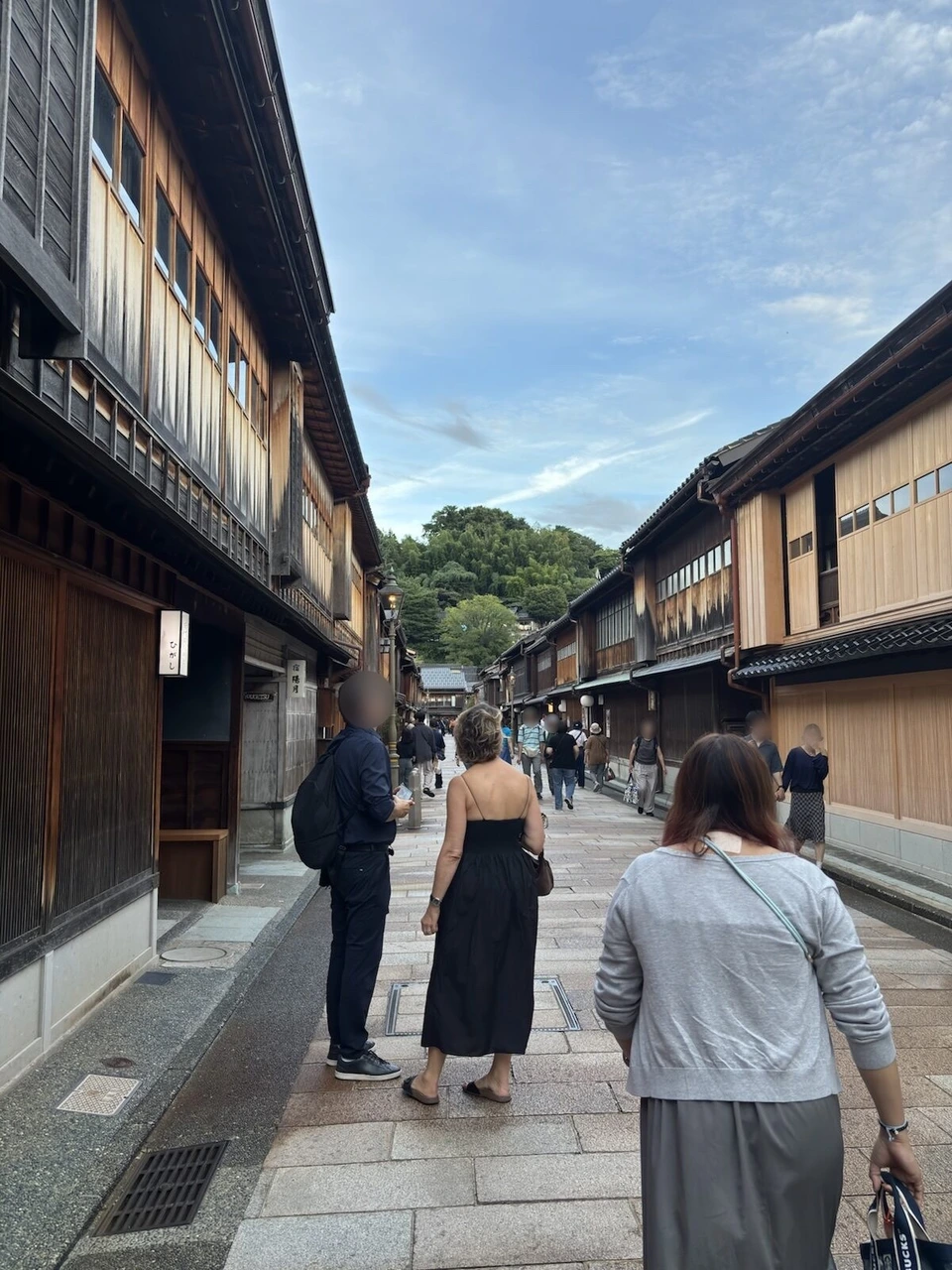 ひがし茶屋街の石畳の通りを歩く観光客と、両側の町家